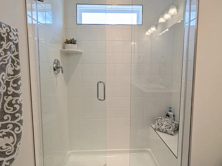 En-suite TILE-shower, sun window, rainfall shower head, glass doors, bench.