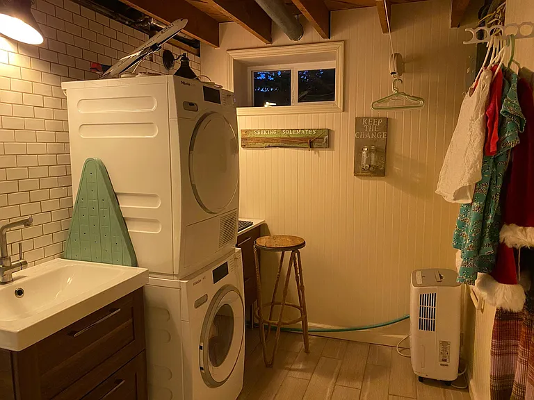 Downstairs laundry with built-in storage and options for ecofriendly clothes drying