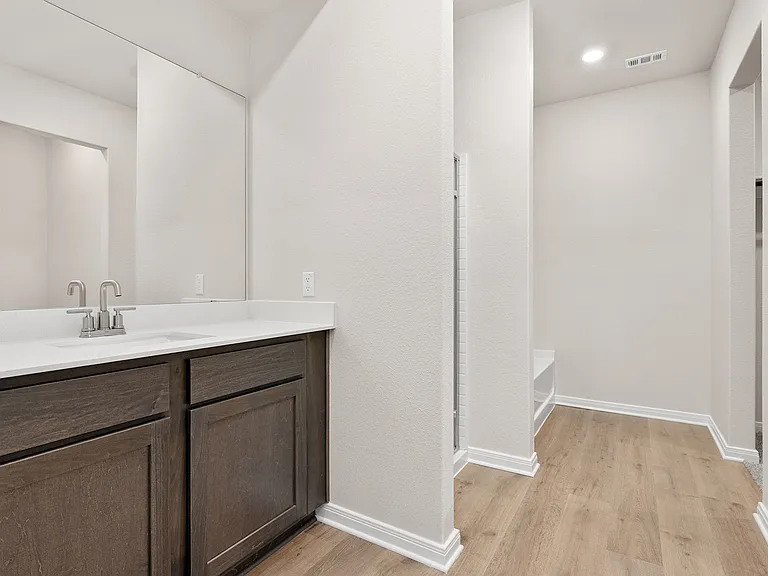 The master bathroom has a sprawling vanity, glass walk-in shower and a garden tub.
