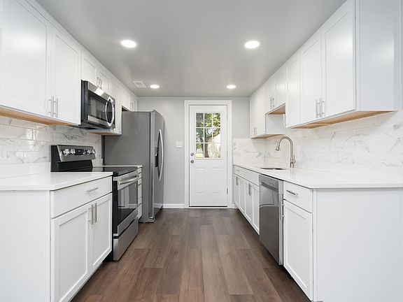 Kitchen with new cabinets, granite, tile backsplash and new stainless steel appliances.
