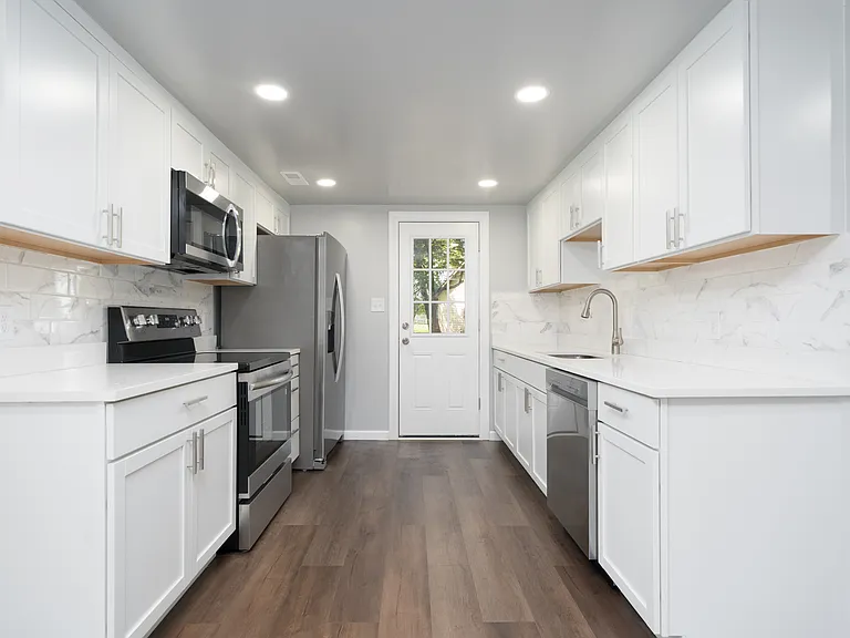 Kitchen with new cabinets, granite, tile backsplash and new stainless steel appliances.