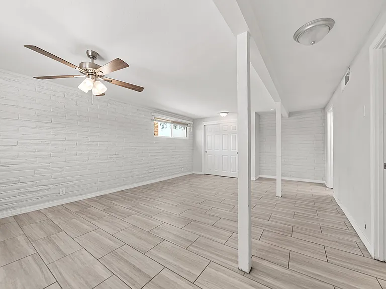 Expansive primary suite with a stylish brick accent wall and its own private hallway.