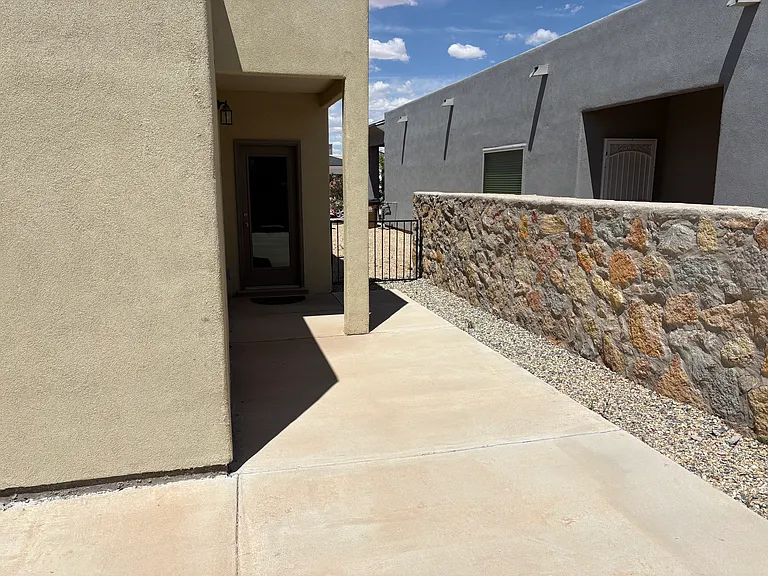 Side yard with a low gate and back door to the house.