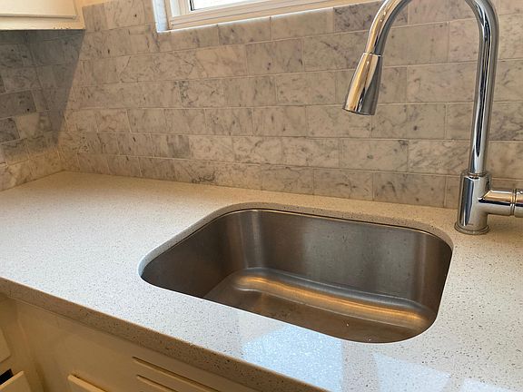 Stone counter tops, under mount sink with Carrera backsplash