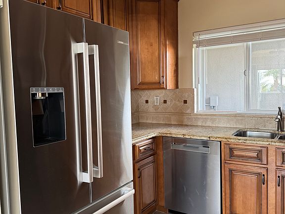 Kitchen with new Bosch refrigerator and dishwasher, updated cabinets, backsplash and granite countertop.