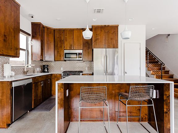 Quartz counter tops in kitchen along with stainless steel Bosch appliances. Fully equipped kitchen with coffee maker and cooking utensils. Large island that seats 2.