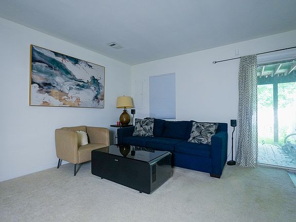 Living room with couch, chair, and smart fridge table.