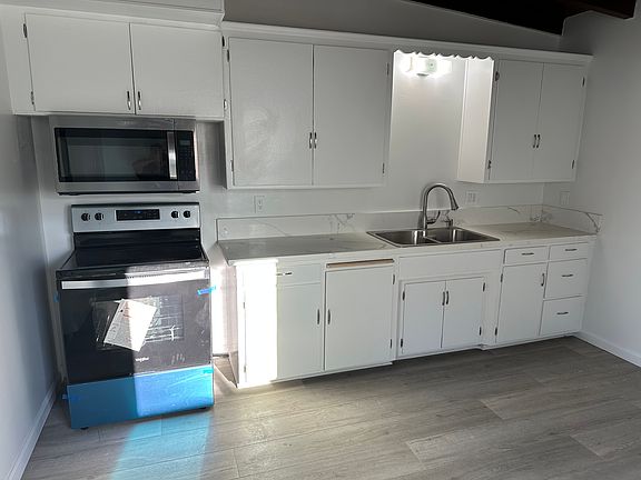 New microwave, electric stove, and fridge.