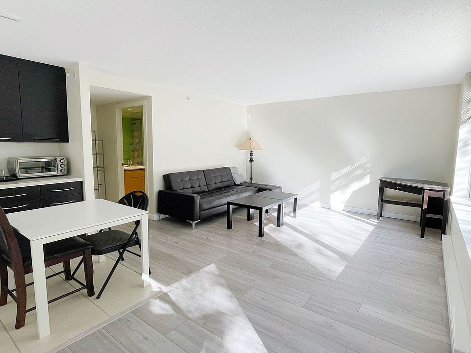 Living Room: Furnishings include leather sofa, dining table with chairs, floor lamp, nightstand, and storage cabinets