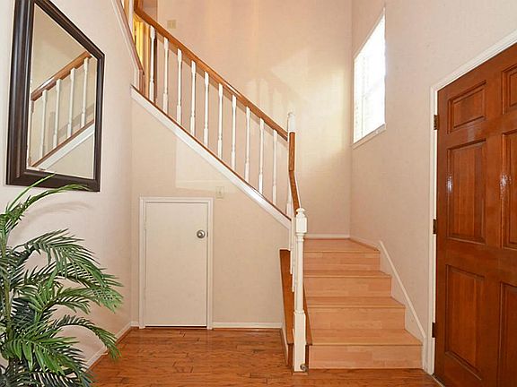 This impressive entry boasts of rich genuine wood flooring and 2 story high ceilings! NO wasted space with storage under the stairs!
