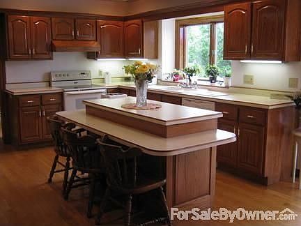 Spacious Kitchen : Custom cabinets, open soffits, hardware floors. Patio doors open unto deck.