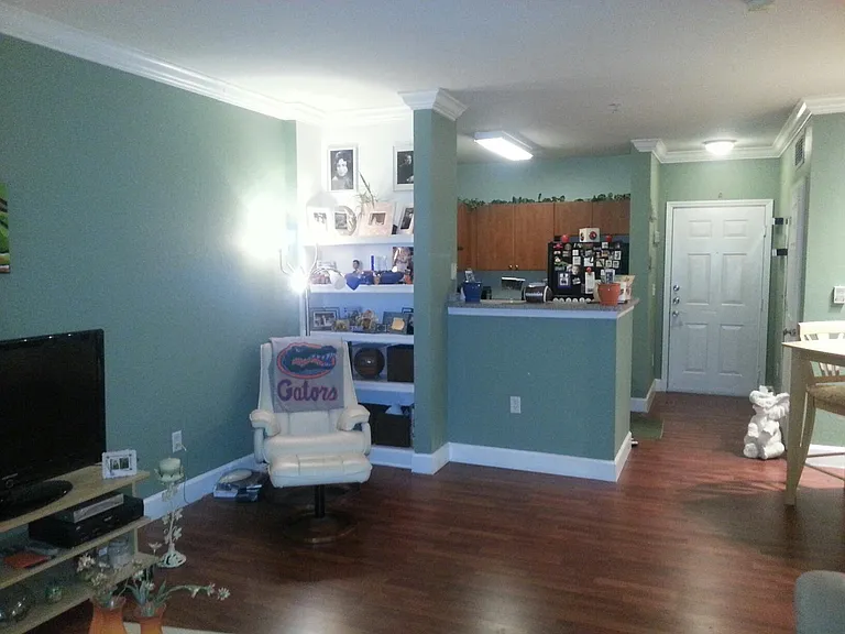 Living room with view of kitchen and front door.