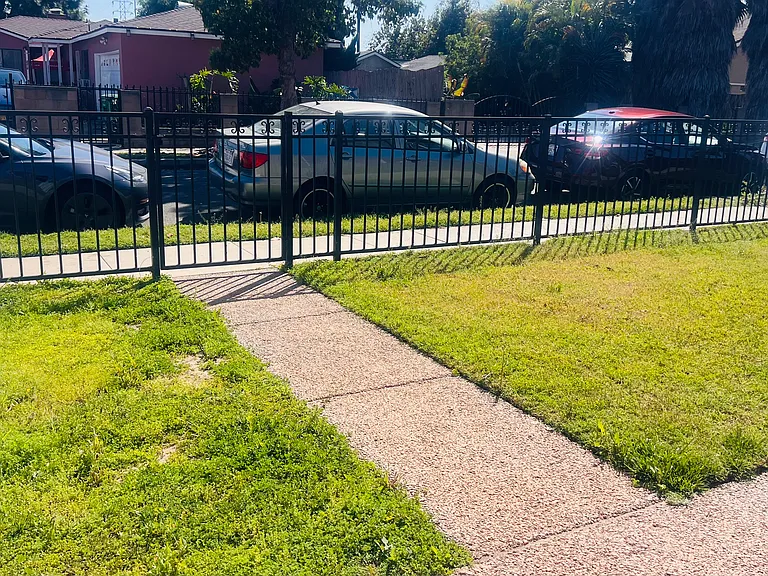 Gated and Fenced front yard w/ grass & concrete