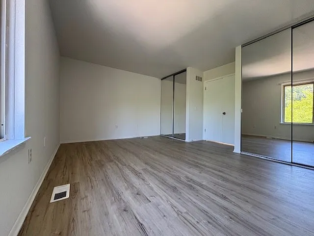 Primary suite with french doors and 2 closets with 8' sliding glass mirror doors