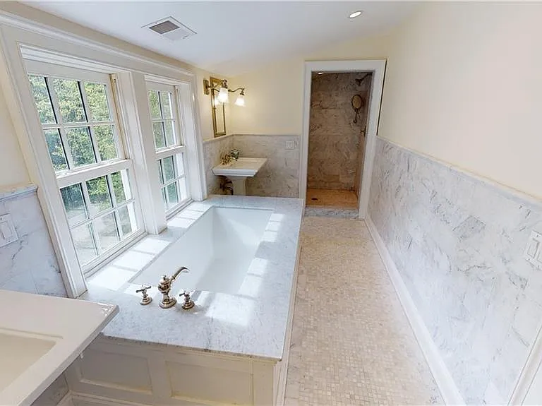 Primary suite bath with walk-in shower at far end and water closet at opposite end