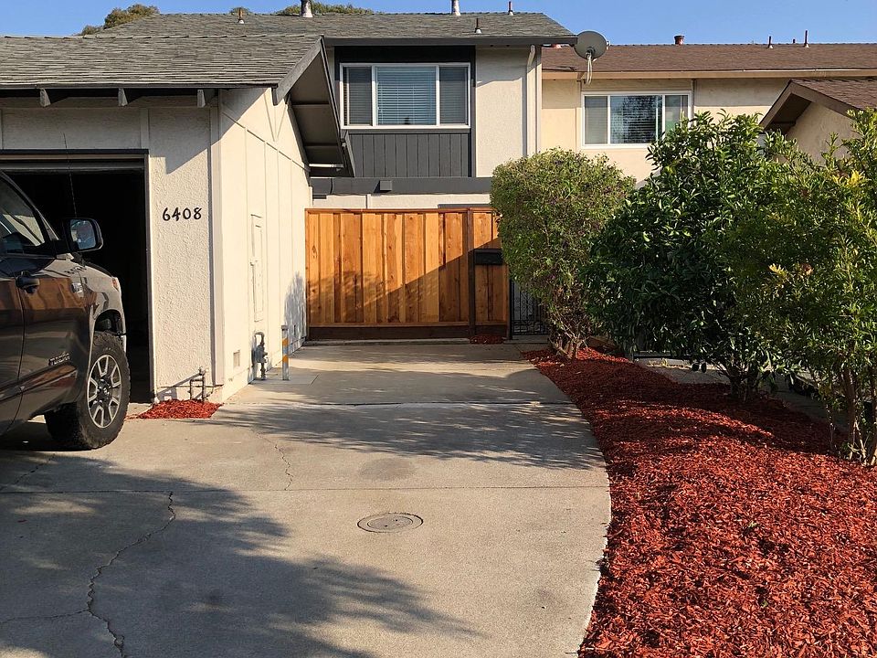 Front yard with single car garage and gated front entrance.