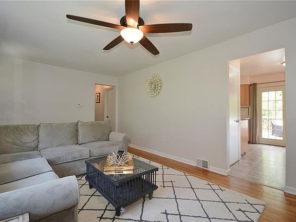 This is a view of the living room into the kitchen with a patio door in the distance adding more natural light.