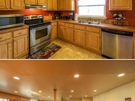 a light-filled kitchen with views of the wooded lot of Glacier Park! Downstairs Walk-Out Den Has Fireplace & Pool Table Included!