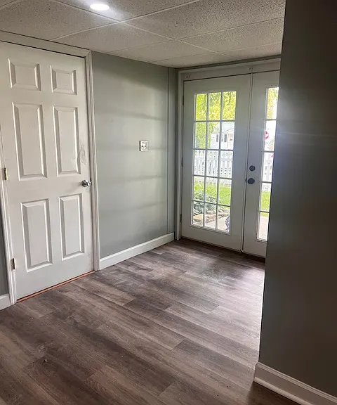 Finished basement, showing door leading to storage and workshop areas