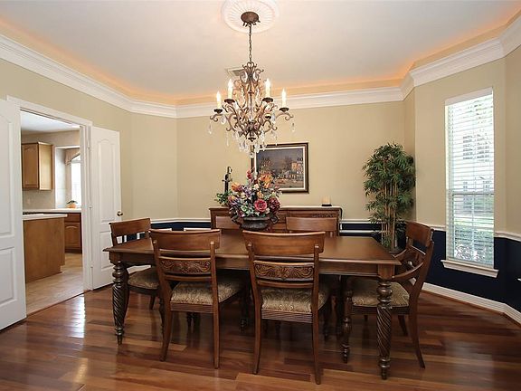 The Sophisticated Formal Dining Room offers Double Crown Molding with Rope Lighting and Gleaming Hardwood Floors.