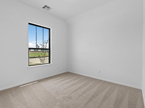 The second bedroom is a welcoming retreat with soft carpet and a large window that fills the space w