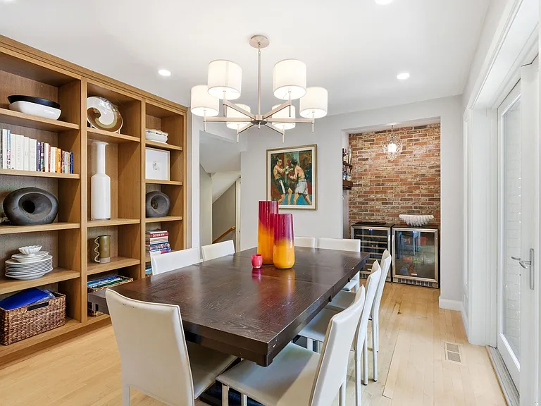 Dining room with beautiful built in shelving, lots of windows and patio entrance as well as adjacent kitchen and bar nook.