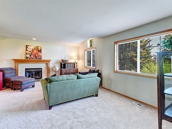 Extra large living room features gas fireplace with tile surround and mantle. 