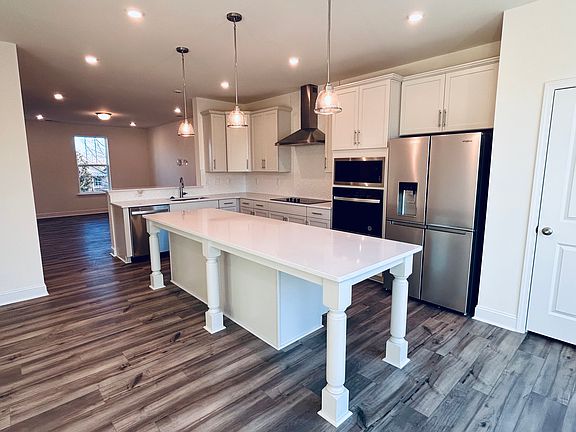 Interior photo, view of kitchen island, kitchen, and living area