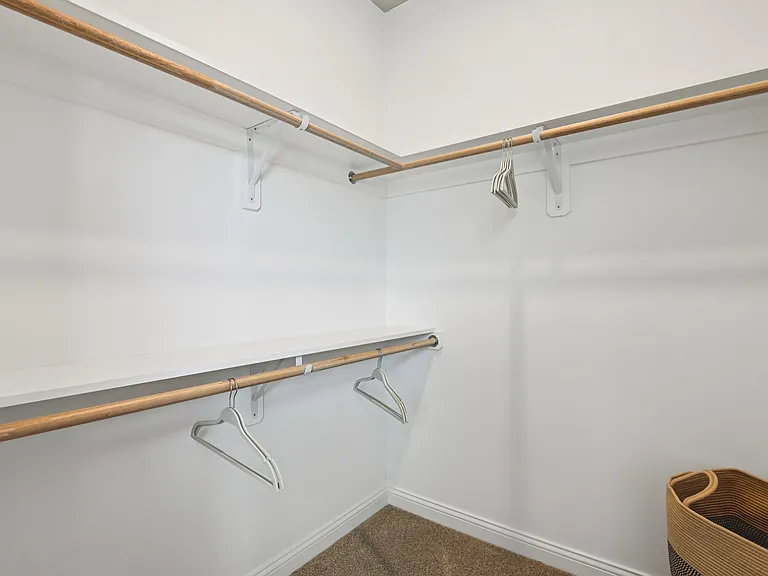 Transform your daily routine with this spacious walk-in closet, designed with generous shelving and hanging areas for a perfectly curated wardrobe.