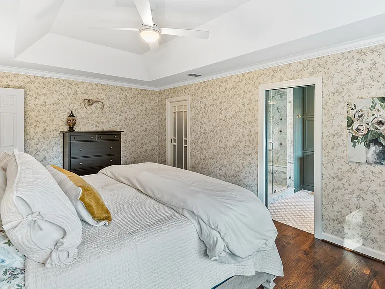 Primary bedroom with a comfortable King bed, room-darkening shades, a ceiling fan, closet, and ensuite bathroom.