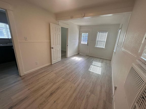 Front room looking from back of room to front door. 8 x8 bedroom door seen open to the left