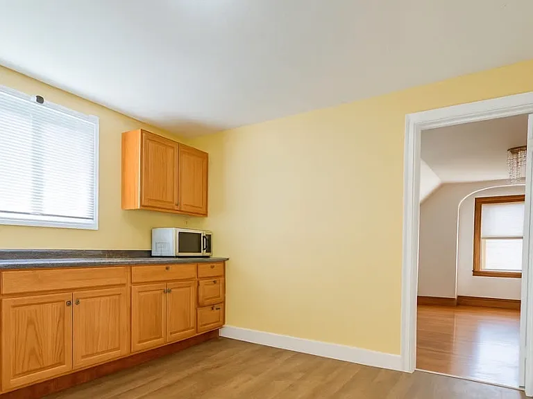 A bedroom and the kitchen are located on the opposite side, with a centrally placed bathroom for added convenience. The kitchen features newly installed cabinets, a large refrigerator, and a gas range, offering a modern and functional cooking space.