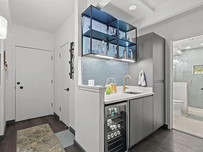 Wet bar and linens storage, with entry door visible on the left side of the image, and bathroom on the right