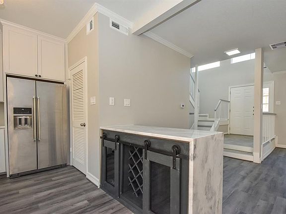 A closer look at the custom waterfall island. The door next to the refrigerator leads to the spacious laundry room and walk-in pantry.