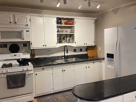 Kitchen with stove, refrigerator and microwave.