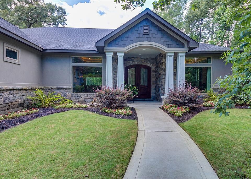 Private entrance into the home with the brush area covering the end of the driveway. Fantastic custom design, extra large windows, and stone treatments all around the exterior.