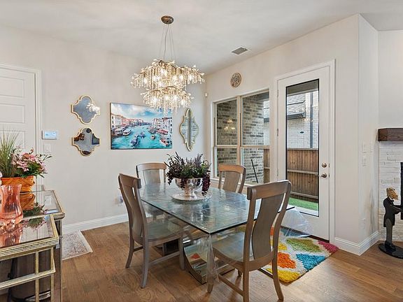 Dining room featuring a fireplace, a chandelier, and wood-type flooring