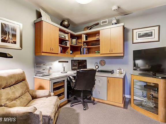 Den with custom built cabinets and shelving.