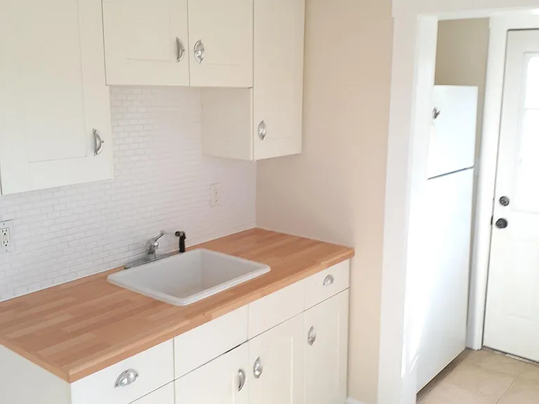 Kitchen sink, fridge nook and door balcony.