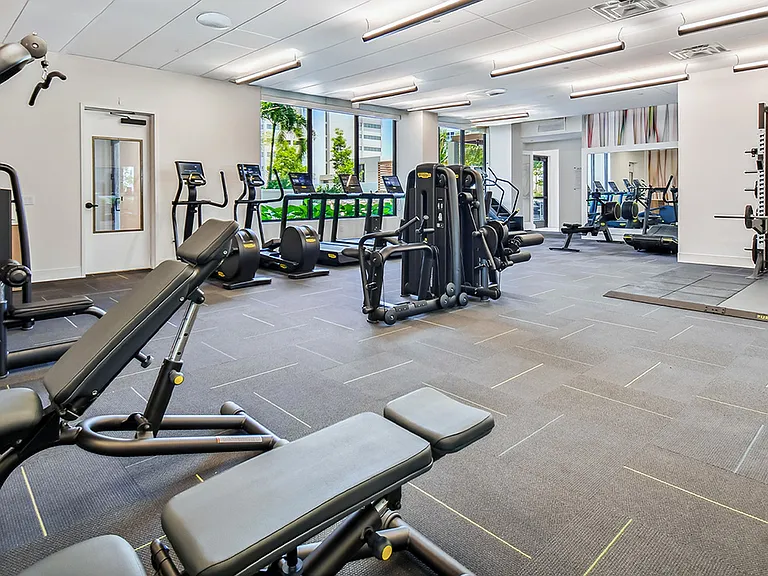 Griffis West Palm apartments fitness center with cardio machines and weight equipment.