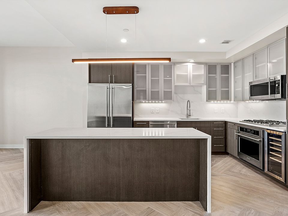 Penthouse kitchens feature frosted-glass cabinet doors, quartz countertops and breakfast bars