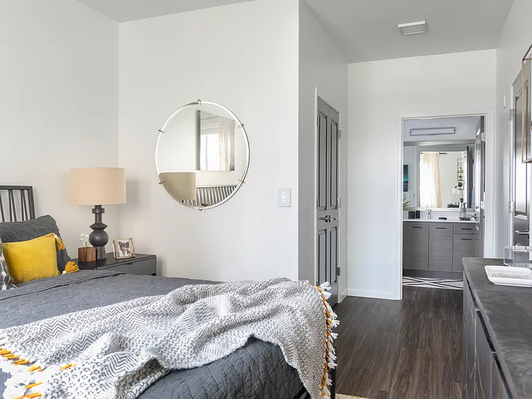 Large bedroom with wood-style flooring and attached bathroom and closet