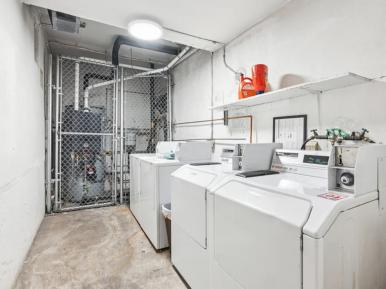 Laundry room with a row of washing machines and dryers