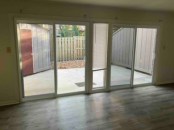 Large fenced-in patio with 2 sliding glass doors