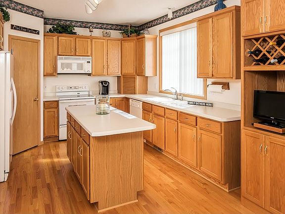 Very functional kitchen with lots of workspace, cabinets and large window above the sink