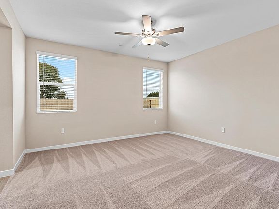 The master bedroom has large windows with a ceiling fan.