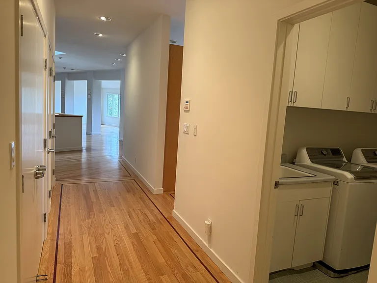 Convenient laundry room includes a utility sink, lengthy countertop and vast amount of storage cabinets.