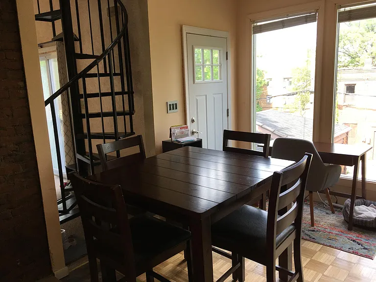Dining area with balcony access and treetop views