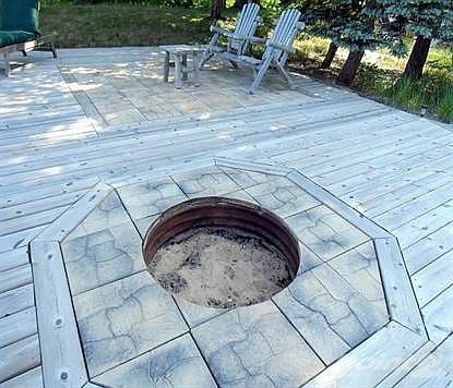 Close detail of fire pit as well as northern expanse of lakeside deck, featuring a unique interplay of wood & stone design materials.