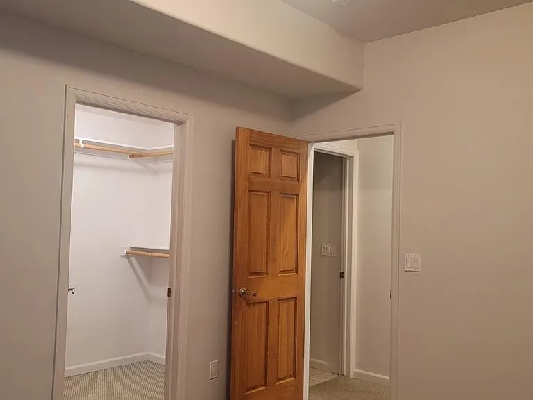Second guest bedroom looking to walk-in closet and guest bathroom prior to new carpet